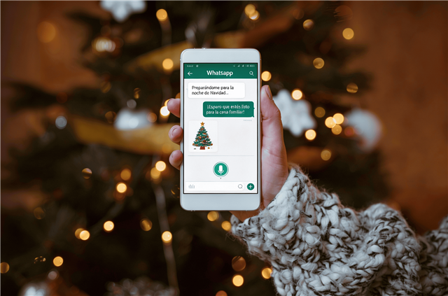 Fondo navideño. Una mano muestra la pantalla de un móvil.